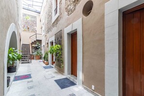 Stroll through this charming corridor, lined with rustic buildings and lush greenery.