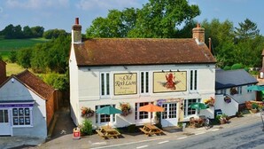 A white building with a sign reading "The Old Red Lion" and outdoor seating with umbrellas. - The Old Red Lion (Thame)