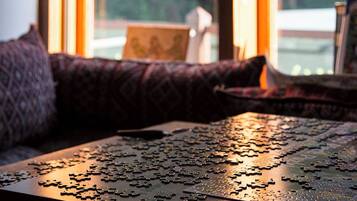 A puzzle on a table near a window with a view of trees.