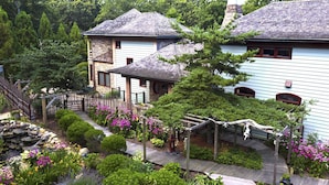 Ein Wohngebiet mit Häusern, einer Holzterrasse und einem Garten mit rosa Blumen.