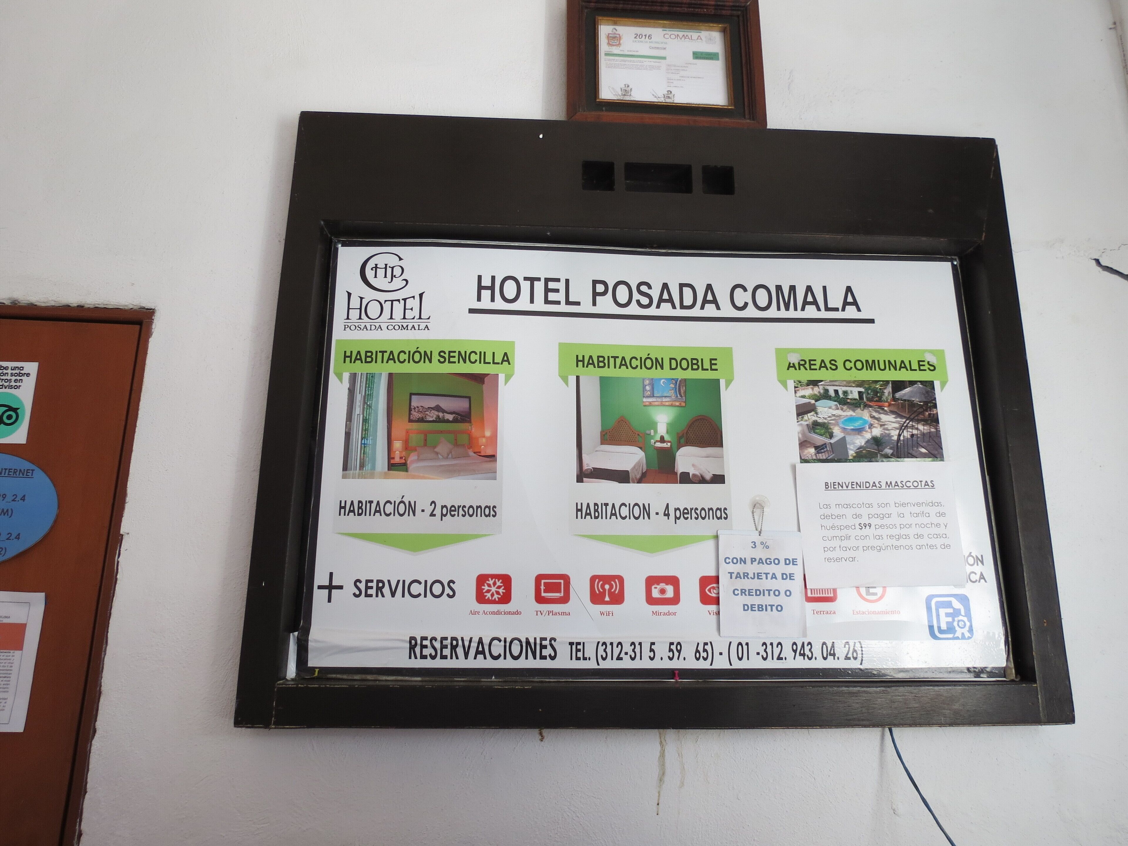 Letrero de hotel que muestra tipos de habitaciones, servicios e información de contacto.