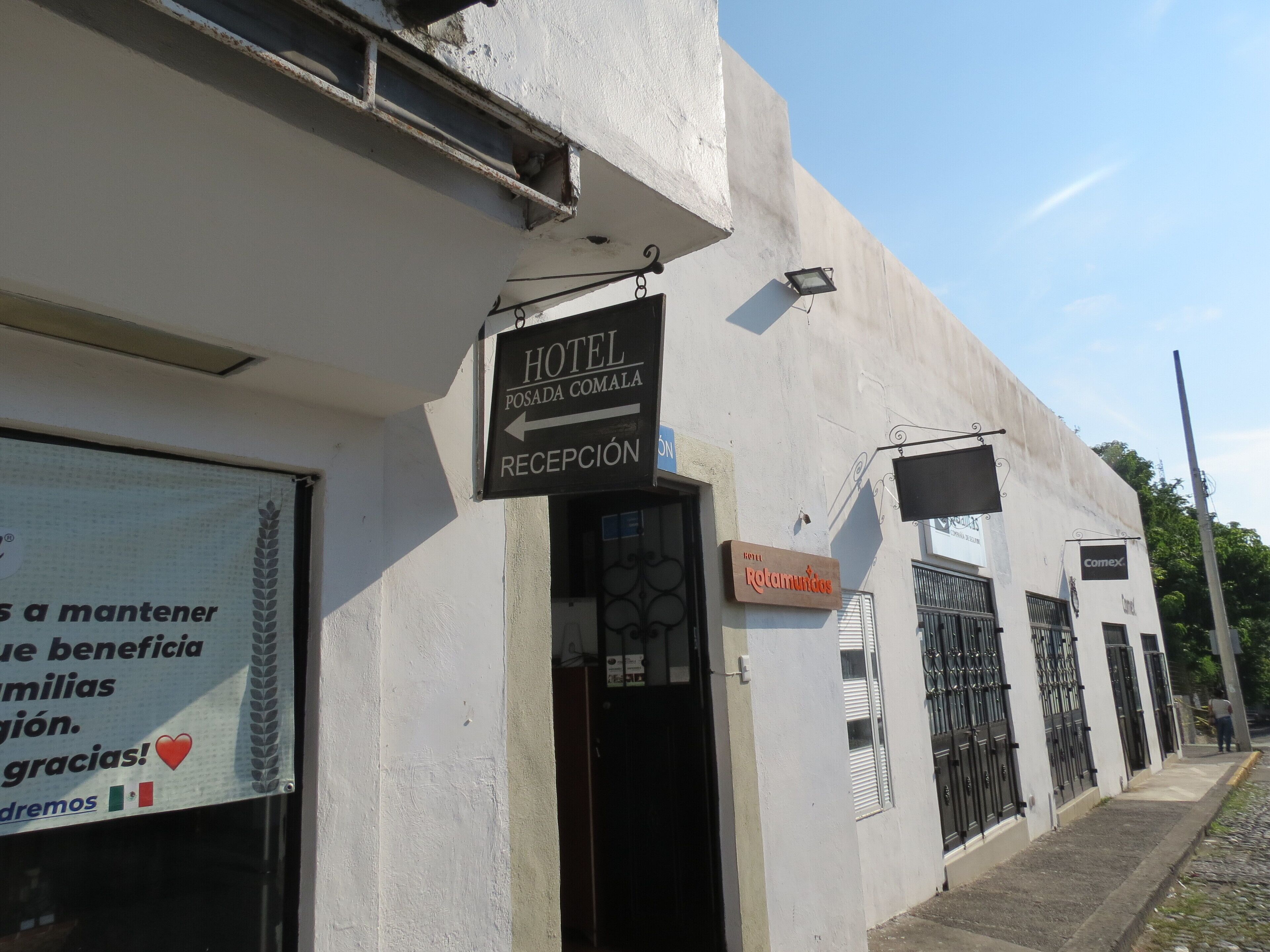 A hotel with a reception area, a sign for 'Hotel Posada Comalapa', and a sign for 'Rotamundos'.