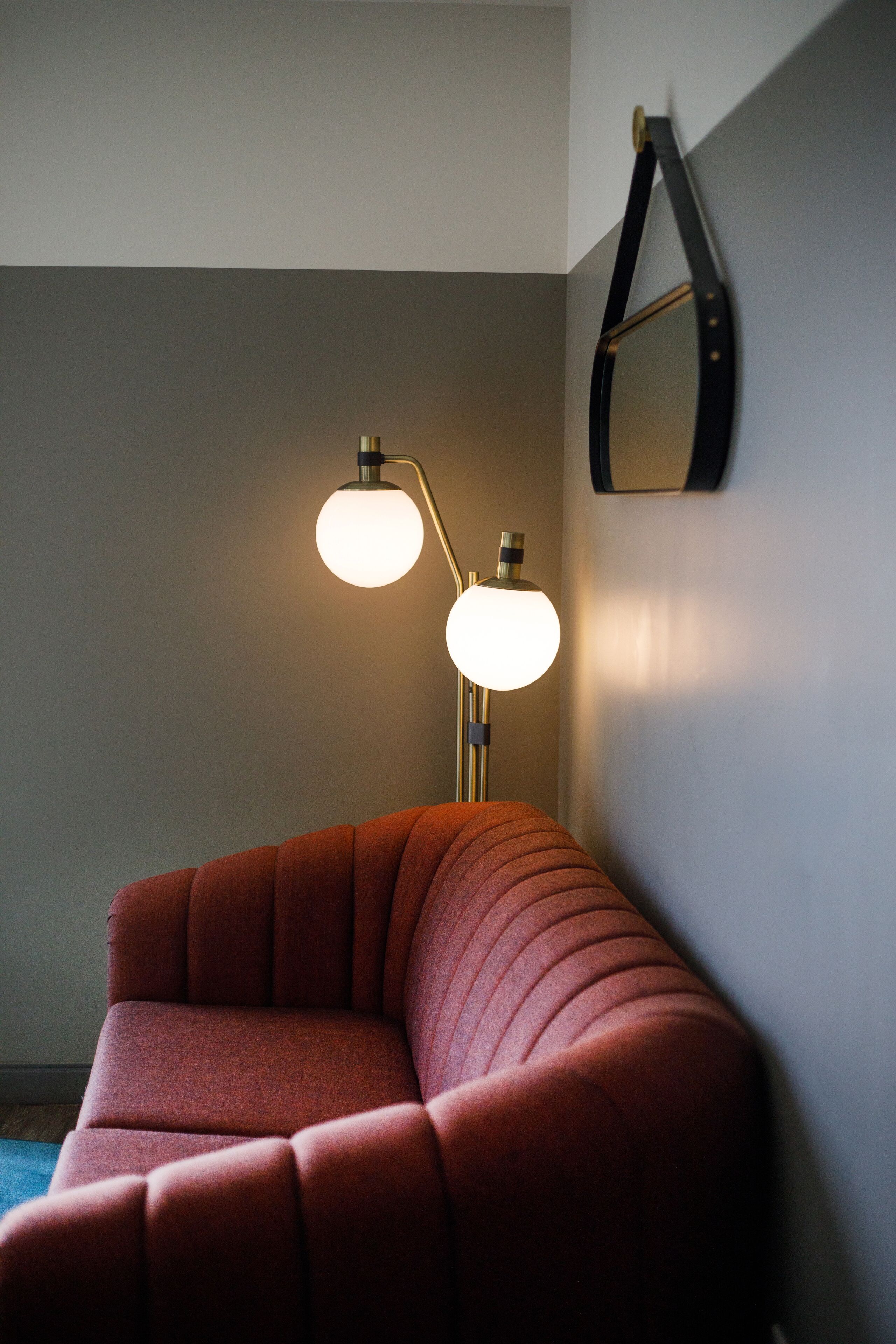 A modern room with a red sofa and a floor lamp.
