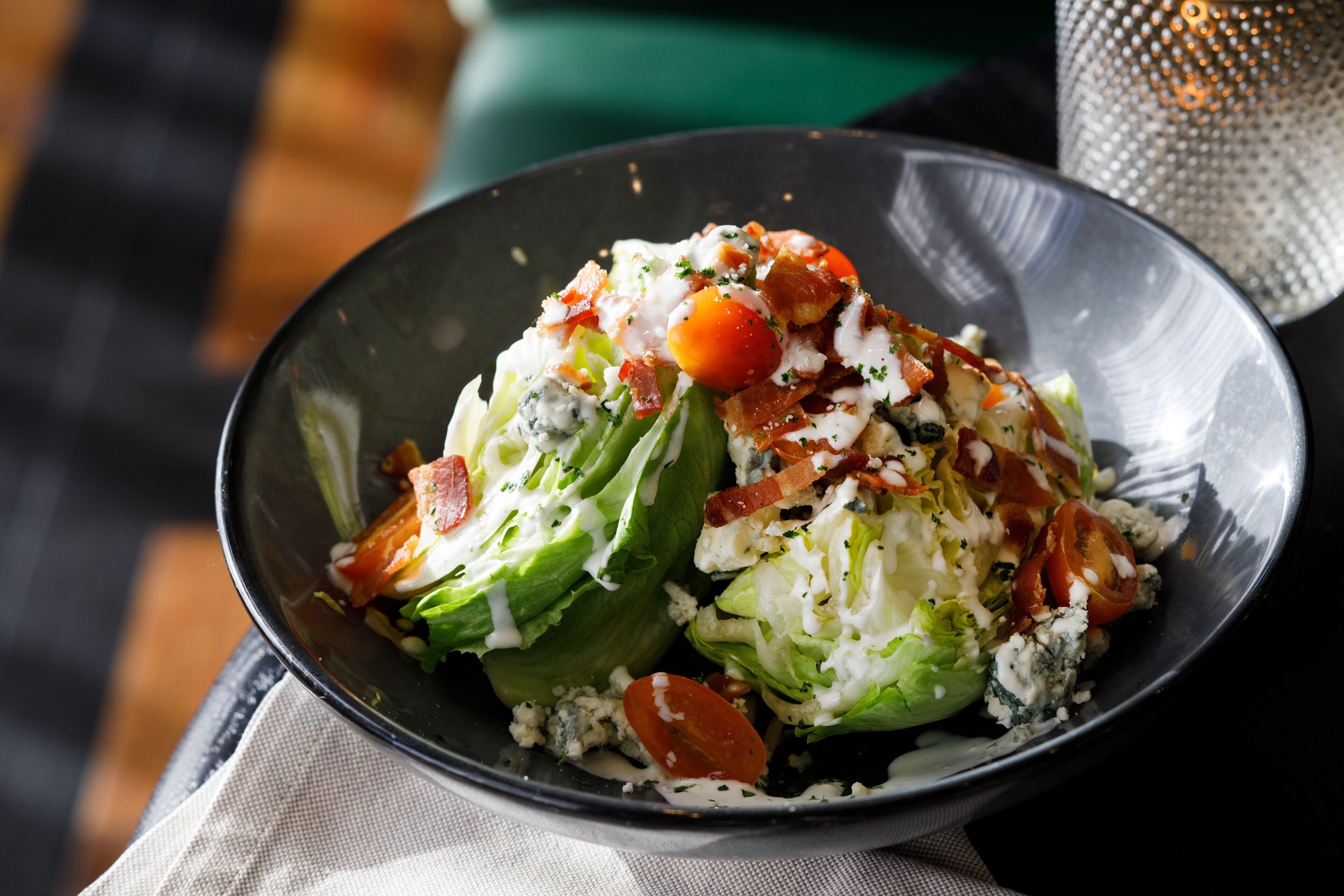 A salad with lettuce, tomatoes, and blue cheese in a bowl.