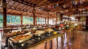 Ein geräumiger Speisesaal mit langen Tischen und Buffet.