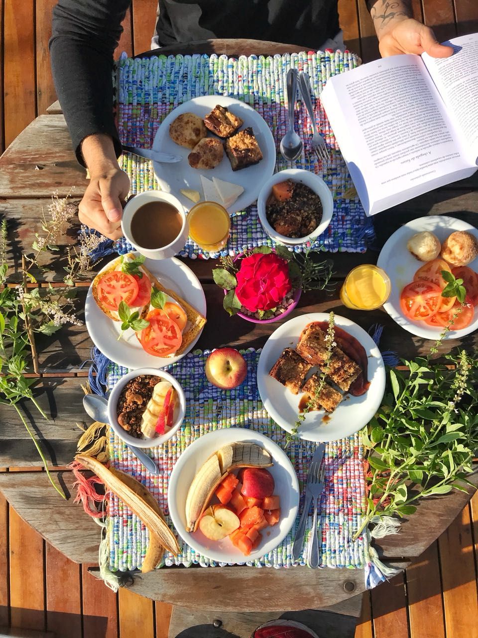 Un montaje para picnic con comida y un libro sobre una mesa de madera.