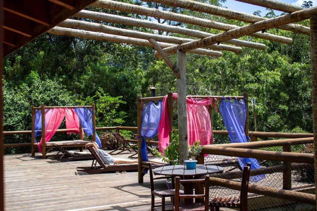 A wooden deck with a table and chairs, surrounded by a bamboo fence.