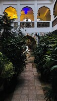 Un percorso interno in giardino con archi decorati e lanterne sospese.