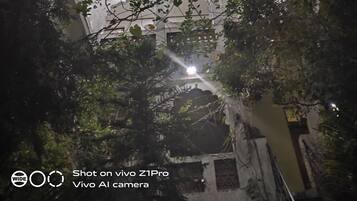 Una vista notturna di un edificio con facciata bianca e numerosi balconi.