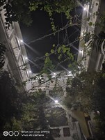 Una vista notturna di un edificio con facciata bianca e numerosi balconi.