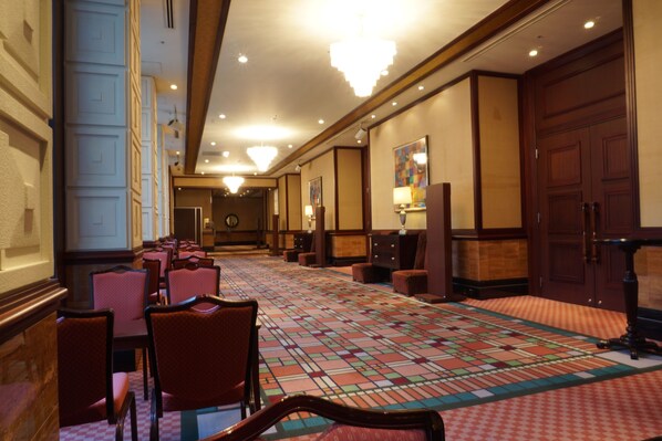 A hotel lobby with a checkered carpet, wooden paneling, and a chandelier. - Mito Plaza Hotel (Mito)