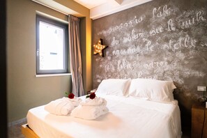 A hotel room with a bed, a star-shaped light fixture, and a wall with a message in a foreign language. - B&B Dei Poeti (Civitanova Marche)