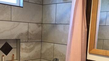 A bathroom with a bathtub, toilet, and a shower curtain.