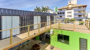 Un edificio moderno con terraza de madera y pared verde.