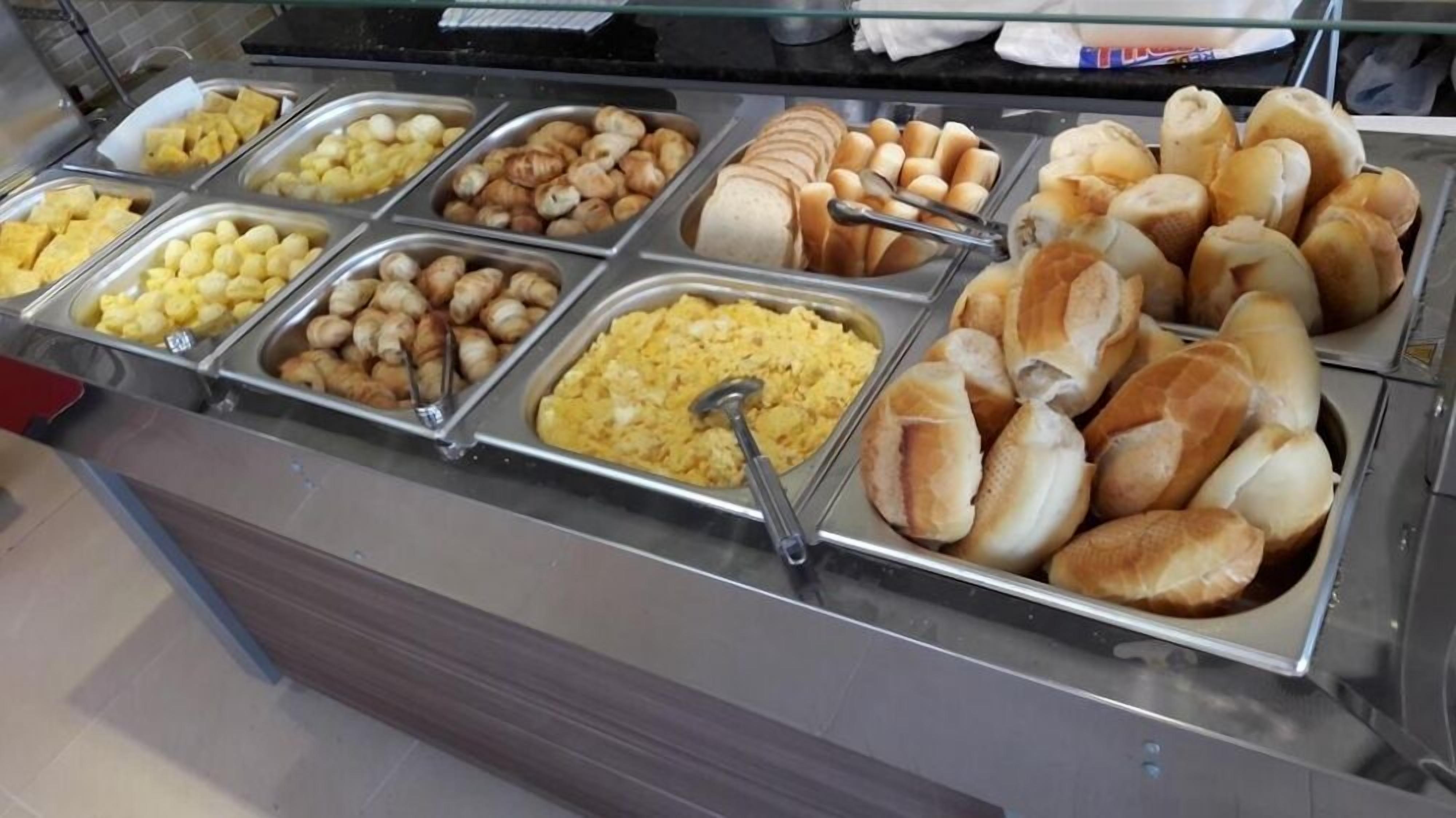 Un bufé con diversas opciones de comida, incluyendo pan, pastelería y huevos.