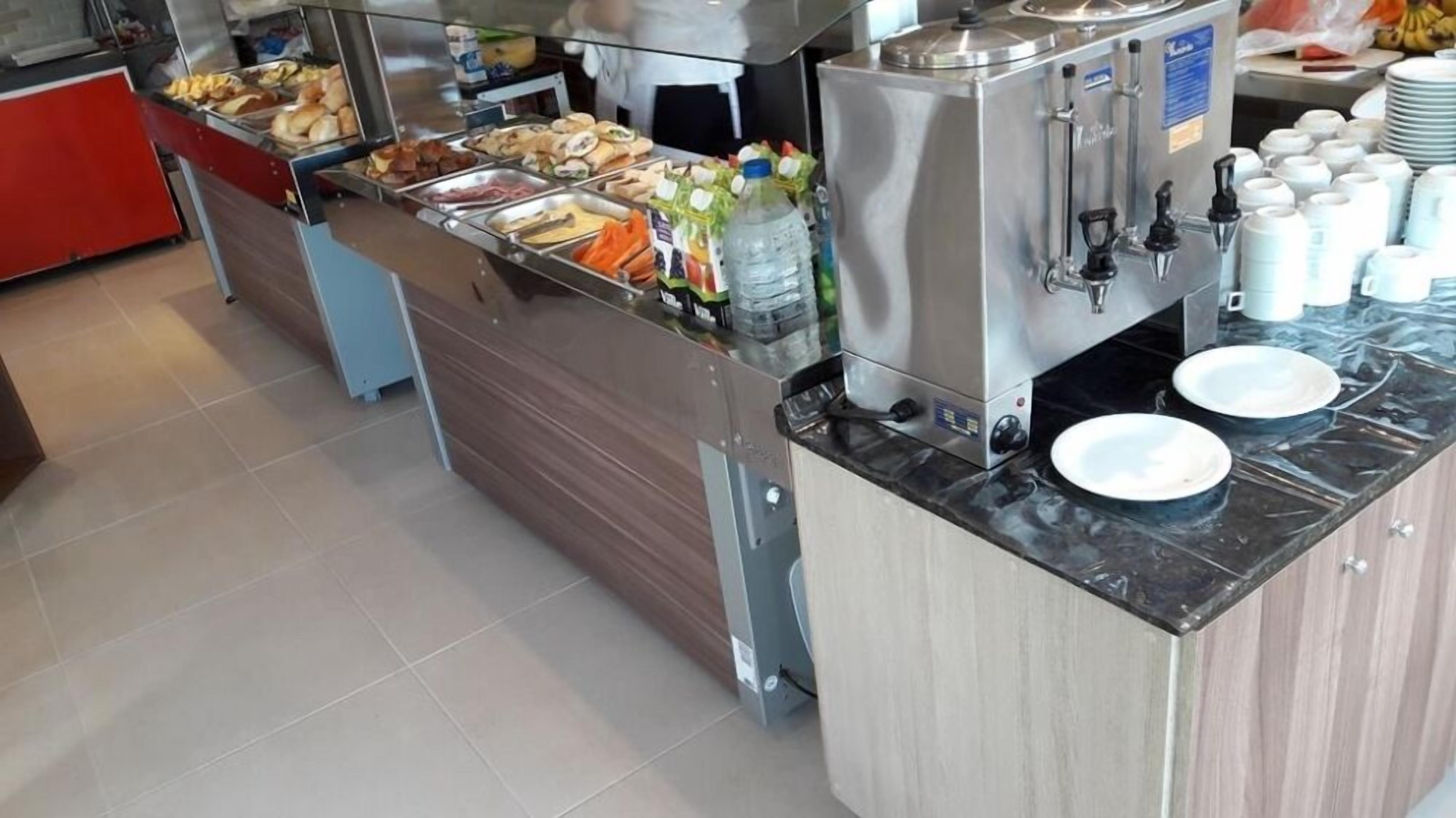 A buffet setup with various food items and a beverage dispenser.