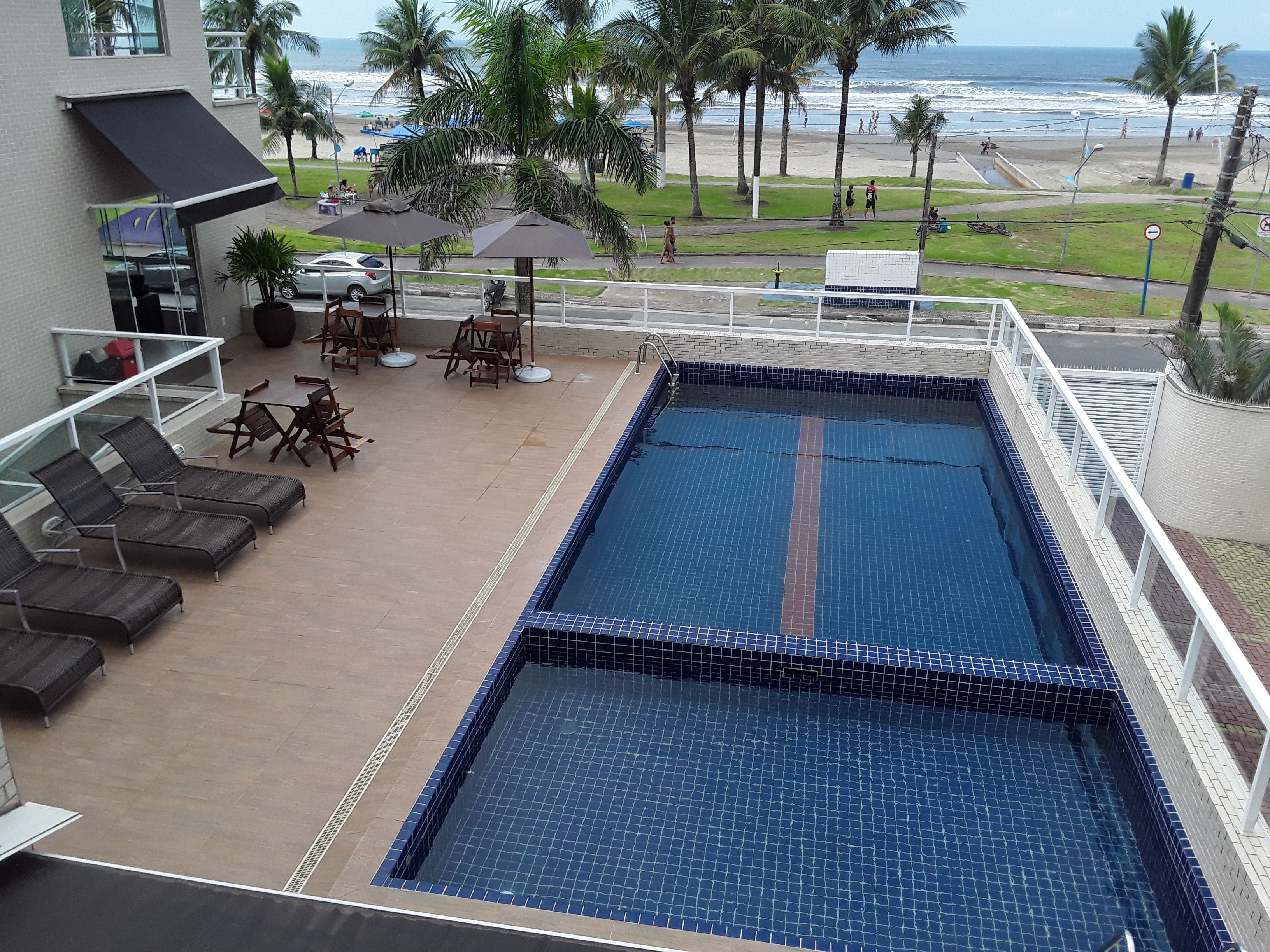 A rooftop pool with a view of the beach and ocean.