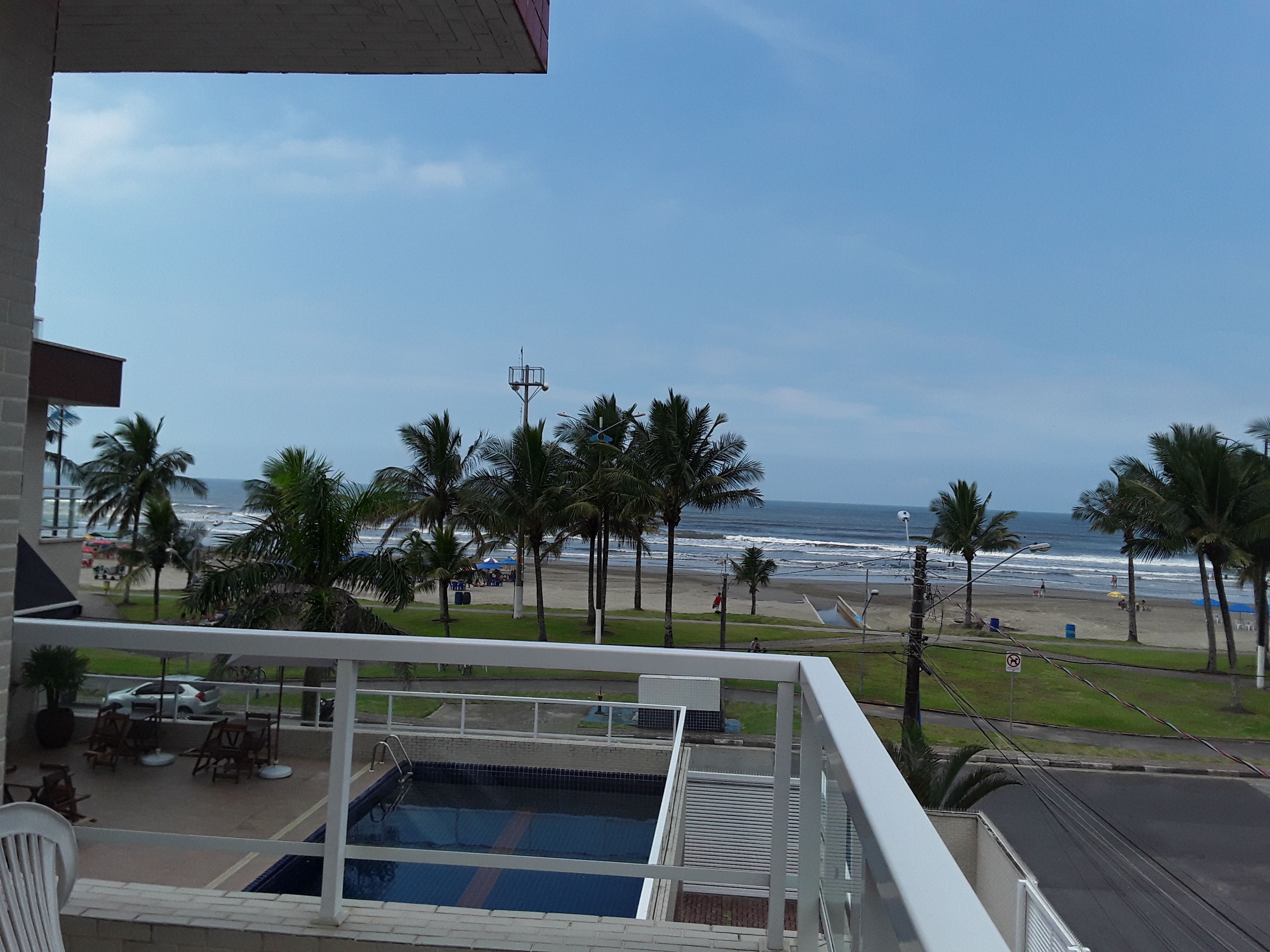 Un espace piscine offrant une vue sur la plage et l’océan.