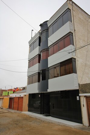 A multi-story building with a modern design, featuring large windows and a flat roof. - G-Boss Hotel Sur (Lurín)