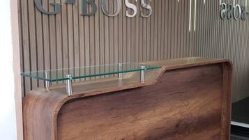 A reception desk with a wooden finish and a glass top.