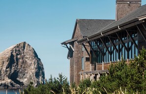 A modern building with a wooden facade and large windows, situated near a rocky landscape. - Headlands Coastal Lodge & Spa (Pacific City)