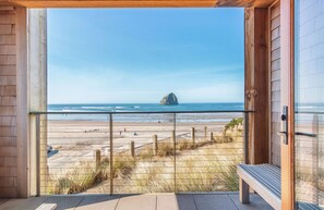 Un balcon avec vue sur la plage et l’océan.