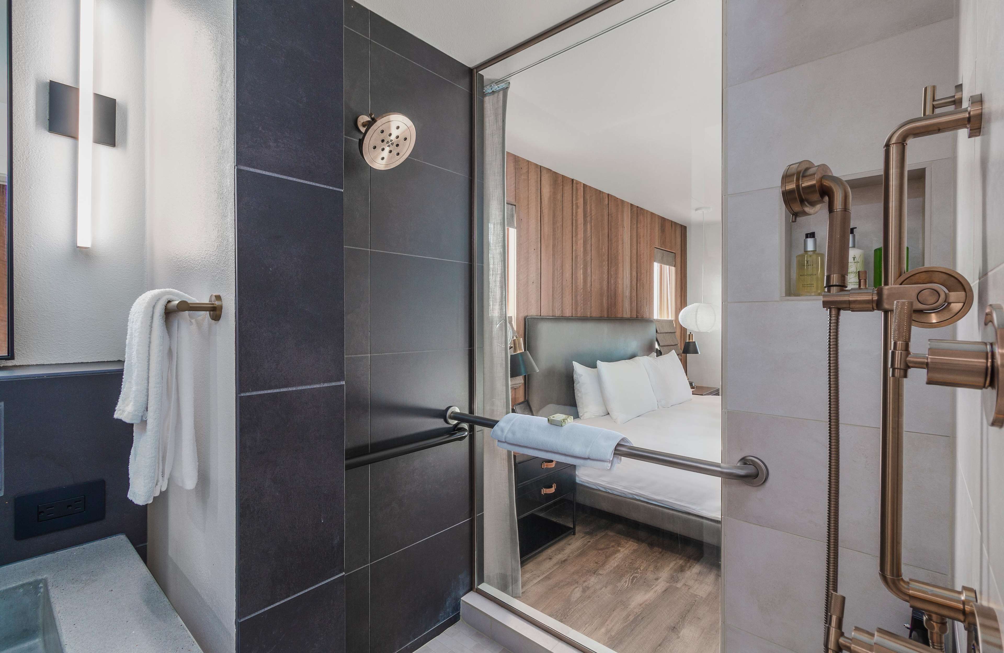 A modern bathroom with a glass shower enclosure, a visible towel rack, and a visible showerhead.