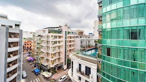 A multi-story building with a pool on the rooftop, surrounded by other residential buildings. - Bella VT Hotel - Bai Sau Vung Tau (Ho Chi Minh City)