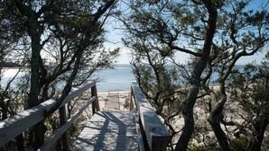 A wooden boardwalk leading to a beach with trees on both sides. - Indian Pass Fun,  Private & Cozy Beach Cottage--The Barnacle (Port St Joe)