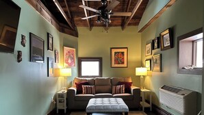 A cozy living room with a sofa, ottoman, and a ceiling fan. - 1 bedroom with SPA bathroom and mountainside deck  (Jim Thorpe)