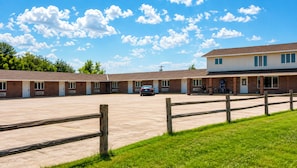 A motel with a parking lot, a car, and a grassy area. - Drop Tyne Lodge (Franklin)