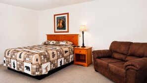 A bedroom with a bed, a nightstand, a lamp, a brown armchair, and a framed picture on the wall. - Drop Tyne Lodge (Franklin)