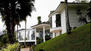 Ein modernes Haus mit gewölbtem Dach, großen Fenstern und einem gepflegten Rasen.