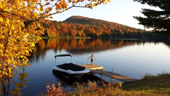 A serene lake with a dock, surrounded by autumn foliage and a hill in the background. - Fabulous All-Season Lakehouse, 600' Lakefront, Lake Eden Vermont (Eden)