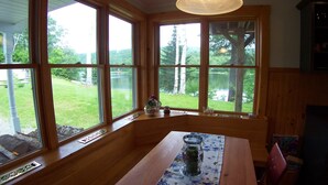 Un intérieur en bois avec de grandes fenêtres donnant sur un espace verdoyant et des arbres.