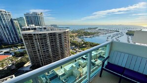 Un edificio alto con vista a un puerto deportivo y barcos.