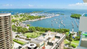 Un puerto deportivo con numerosos barcos, rodeado de vegetación y edificios.