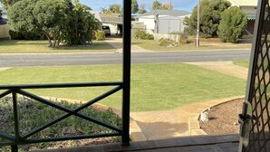 A covered outdoor area with a brick floor and a metal railing.