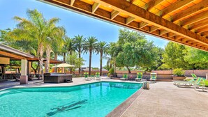 Ein Poolbereich mit klarem Pool, Liegestühlen und Palmen.