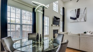Uma sala de estar moderna com uma mesa de jantar de vidro, dois sofás e uma lareira.
