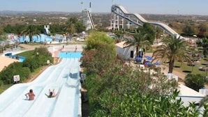 A water park with multiple slides and pools, surrounded by greenery and a clear sky. - You will love a holiday in this beautiful, spacious apartment. Licence 161917/AL (Lagos)