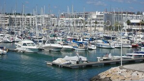 A marina with numerous boats docked, a clear sky, and a building labeled "MARINA DE LAGO" in the background. - You will love a holiday in this beautiful, spacious apartment. Licence 161917/AL (Lagos)