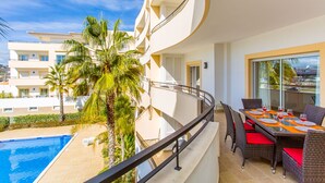 A balcony with a pool, wicker furniture, and a view of other buildings. - You will love a holiday in this beautiful, spacious apartment. Licence 161917/AL (Lagos)