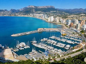 A marina with numerous boats docked, surrounded by a coastal cityscape with mountains in the background. - Calpe: apartment/ flat - Calpe (Calpe)