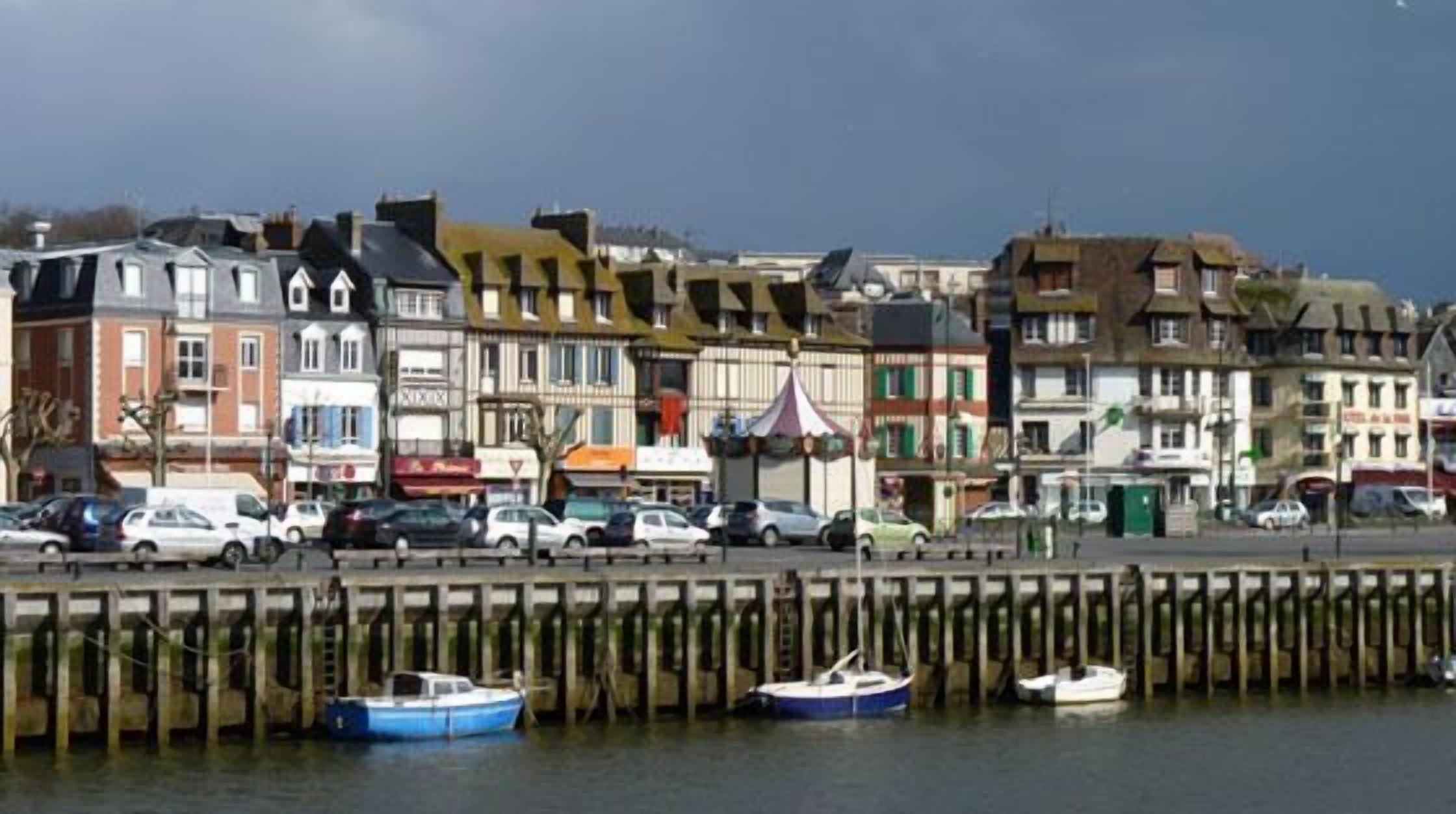 A waterfront with buildings, a pier, and boats.