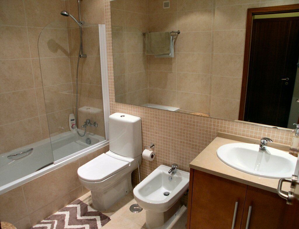 A bathroom with a bathtub, toilet, bidet, and sink.