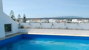 Una piscina en la azotea con vistas despejadas del paisaje urbano.