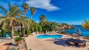 A pool area with lounge chairs, a small pool, and a view of the sea. - .First line luxrury villa. No car needed ,Tram stop 1 minute walking. (El Campello)