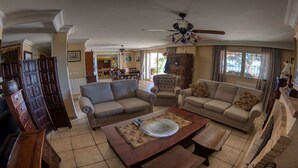 A spacious living room with two sofas, a coffee table, and a ceiling fan. - .First line luxrury villa. No car needed ,Tram stop 1 minute walking. (El Campello)
