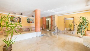 A spacious lobby with marble flooring, large columns, and potted plants. - Coblanca 8-92 (Benidorm)